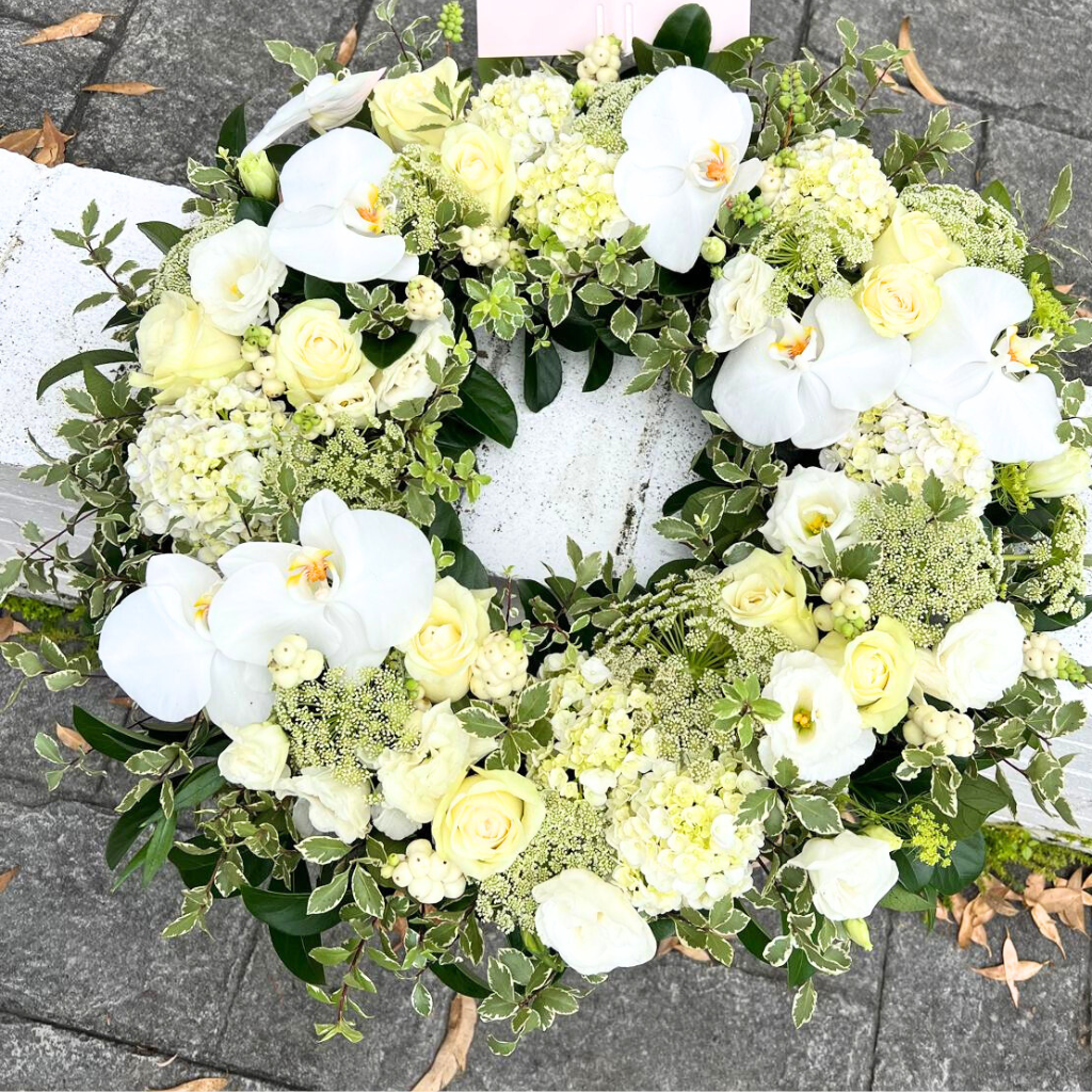Beautiful sympathy floral wreath with an elegant design, featuring soft colours and lush greenery.